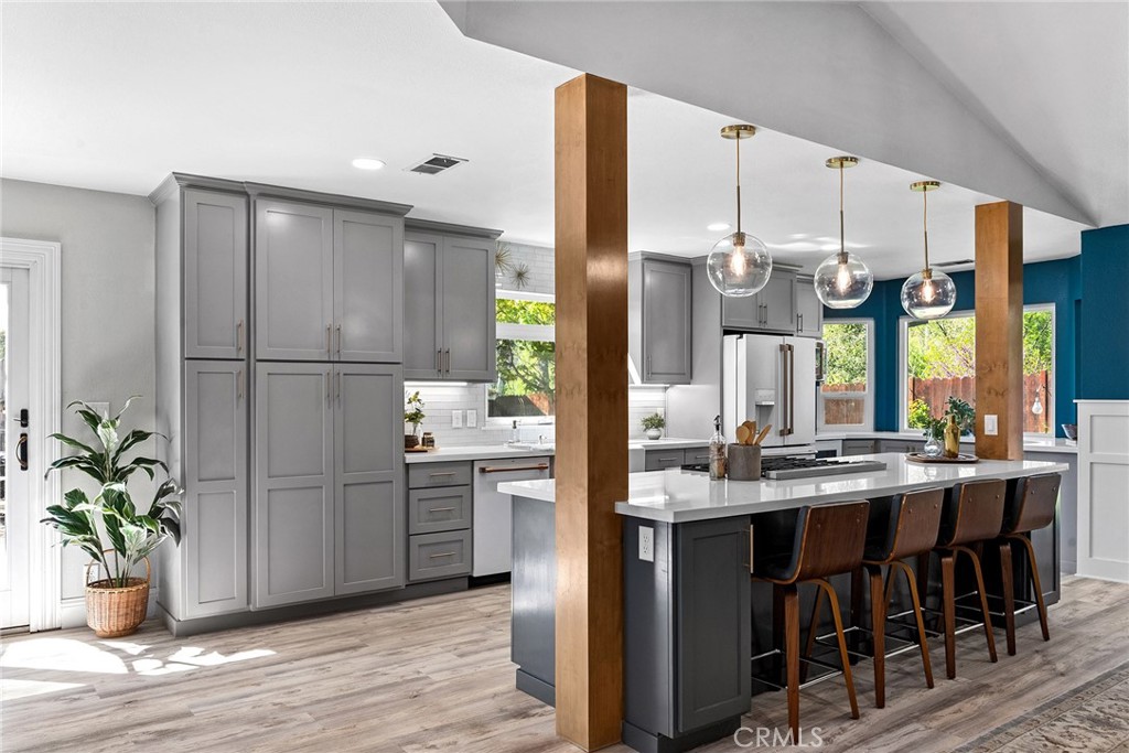 2 Baroni Drive Chico, CA 95928 - Photo 19 of 63 a kitchen with stainless steel appliances kitchen island granite countertop a refrigerator a sink dishwasher and white cabinets with wooden floor