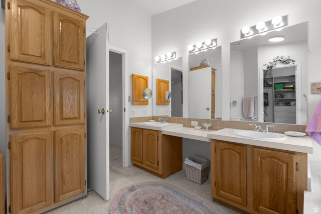 2600 North Hill Field Road, Unit 134 Layton, UT 84041 - Photo 21 of 41 Full bath featuring double vanity, decorative backsplash, and a spacious closet