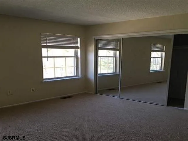 an empty room with windows and closet