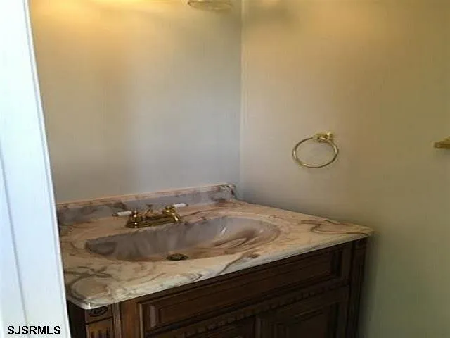 a bathroom with a granite countertop toilet and a sink