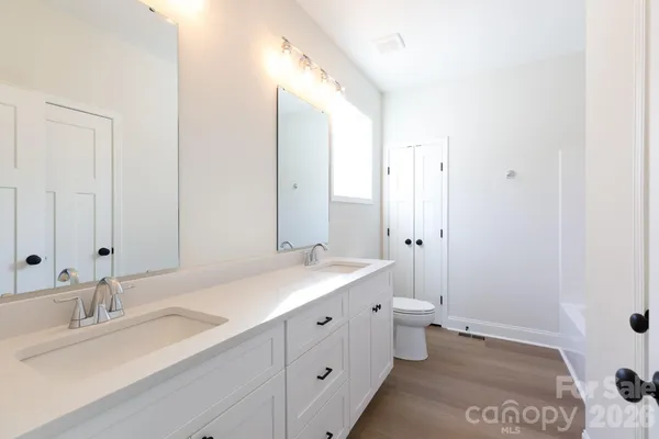 a bathroom with a double vanity sink toilet and a shower