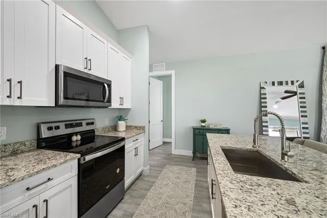 a kitchen with granite countertop a stove and a sink