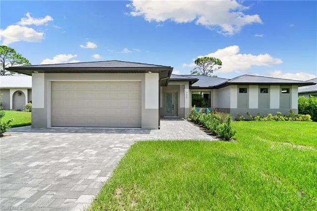 a front view of a house with a garden and yard