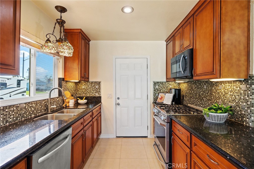 14895 Fairvilla Drive La Mirada, CA 90638 - Photo 13 of 31 a kitchen with stainless steel appliances granite countertop a sink stove and refrigerator