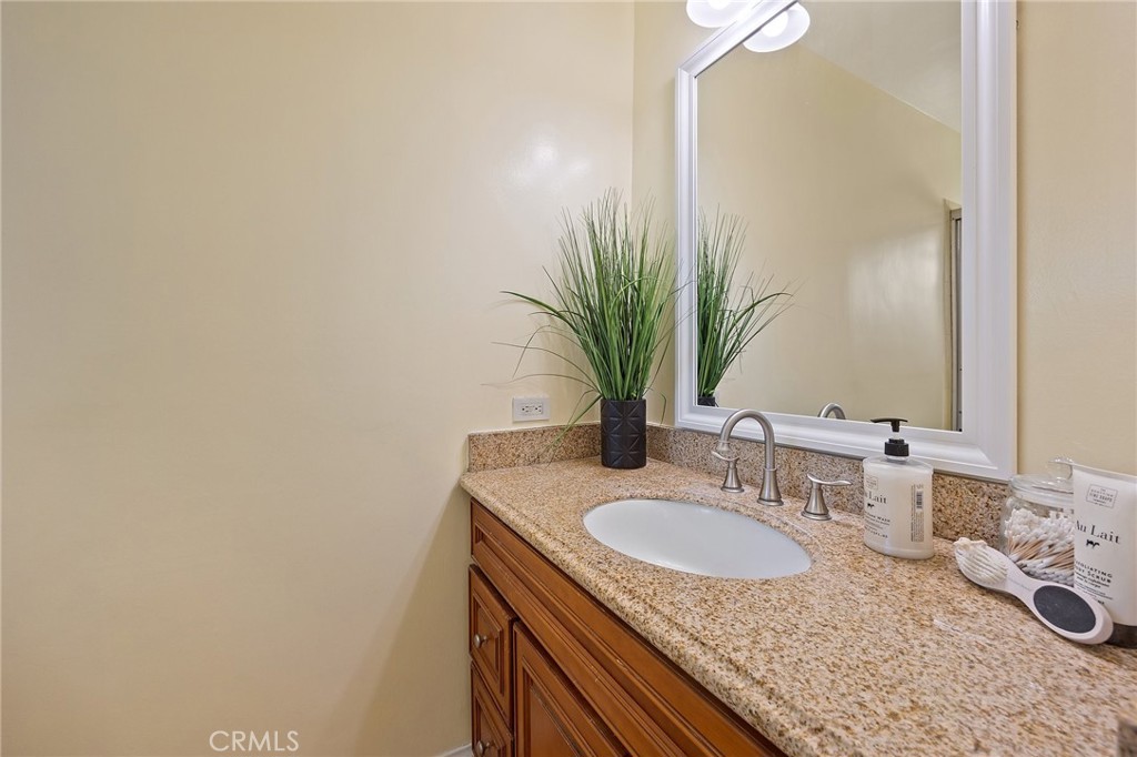 14895 Fairvilla Drive La Mirada, CA 90638 - Photo 19 of 31 a bathroom with a granite countertop sink and a mirror