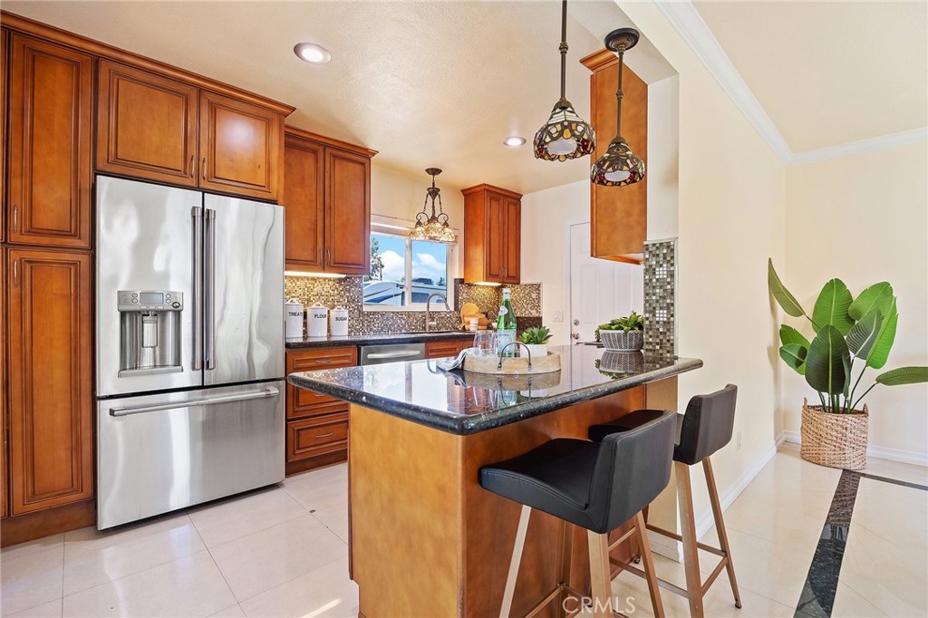 14895 Fairvilla Drive La Mirada, CA 90638 - Photo 10 of 31 a kitchen with stainless steel appliances granite countertop a refrigerator a sink a stove and chairs