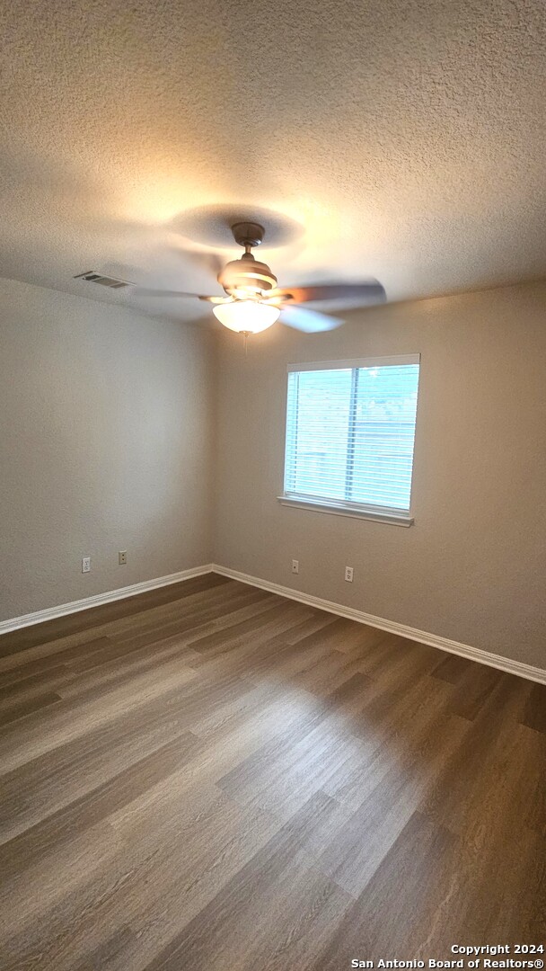 209 Storm Mt Road Cibolo, TX 78108 - Photo 14 of 28 an empty room with wooden floor and windows