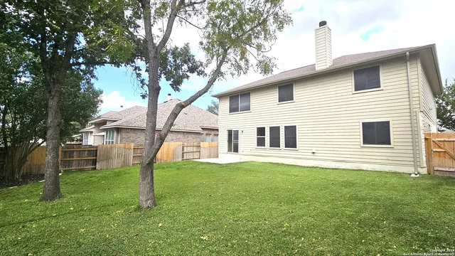 a backyard of a house with table and chairs