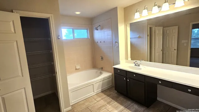 a spacious bathroom with a bathtub sink and mirror