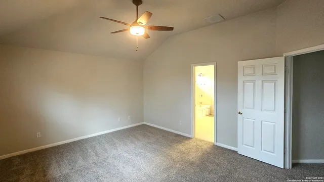 an empty room with a chandelier fan and a window
