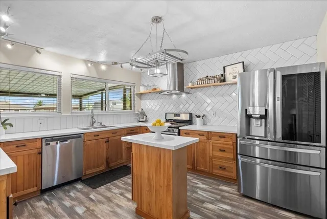 a kitchen with stainless steel appliances granite countertop a sink stove and refrigerator