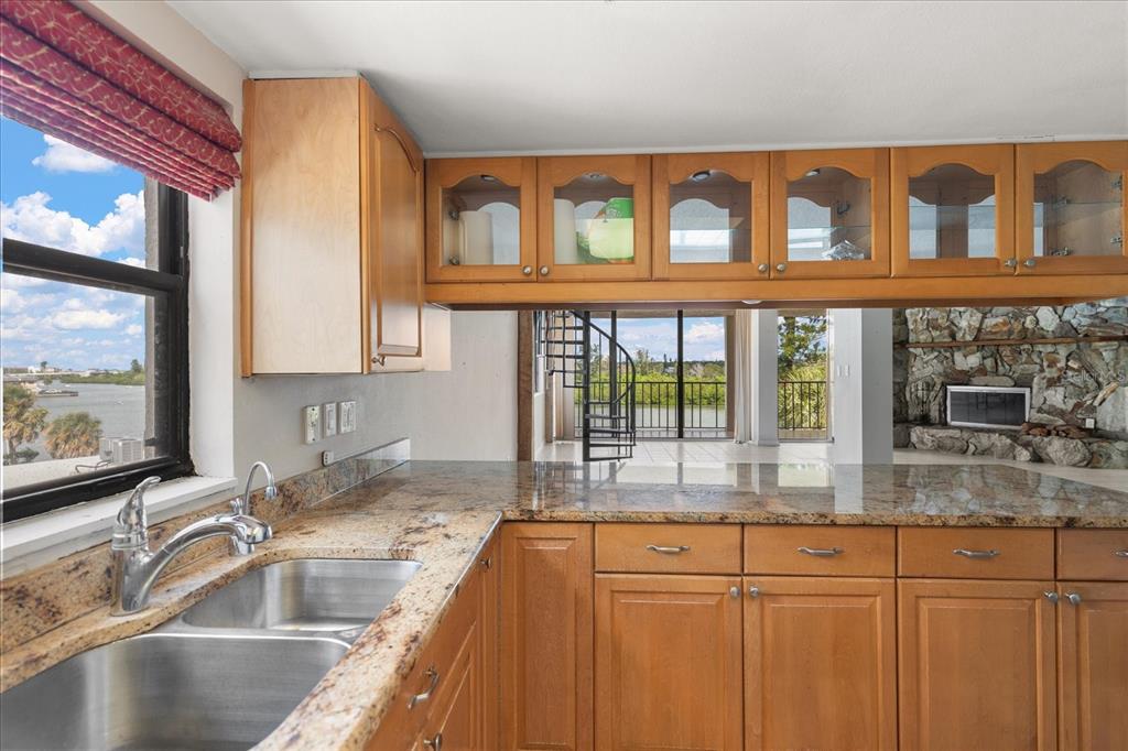 18201 Gulf Boulevard, Unit 401 Redington Shores, FL 33708 - Photo 12 of 42 a kitchen with granite countertop a sink and a window