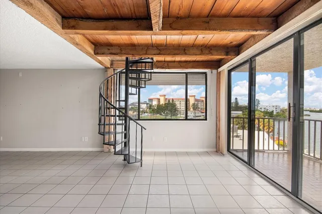 an empty room with floor to ceiling window and outdoor seating