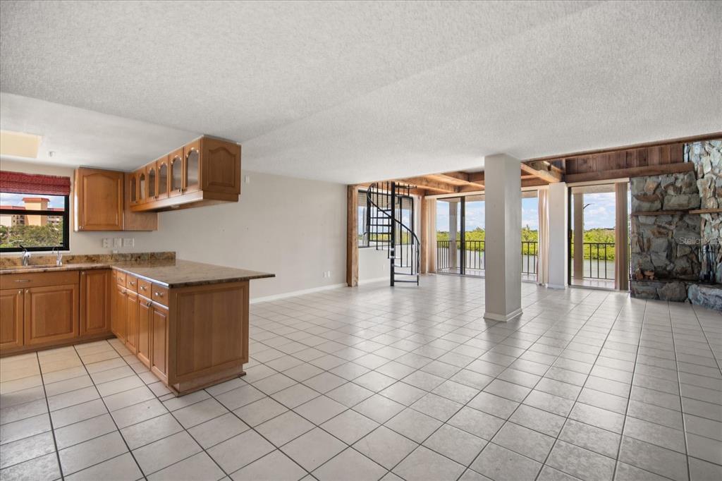 18201 Gulf Boulevard, Unit 401 Redington Shores, FL 33708 - Photo 17 of 42 a kitchen with granite countertop a refrigerator and a stove top oven