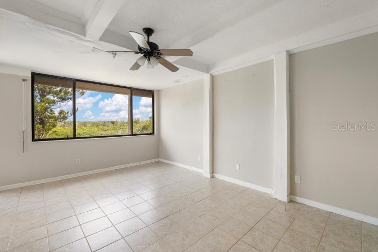 18201 Gulf Boulevard, Unit 401 Redington Shores, FL 33708 - Photo 22 of 42 an empty room with windows and ceiling fan