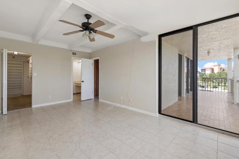 18201 Gulf Boulevard, Unit 401 Redington Shores, FL 33708 - Photo 24 of 42 an empty room and chandelier fan windows and closet in a room
