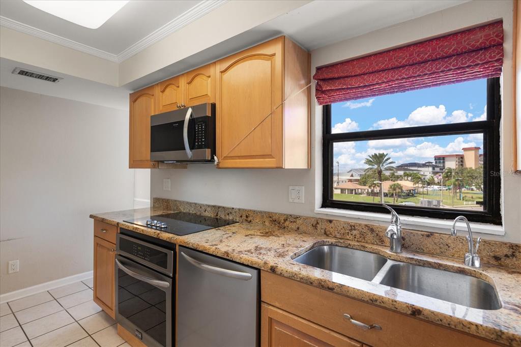 18201 Gulf Boulevard, Unit 401 Redington Shores, FL 33708 - Photo 10 of 42 a kitchen with stainless steel appliances granite countertop a sink and a microwave