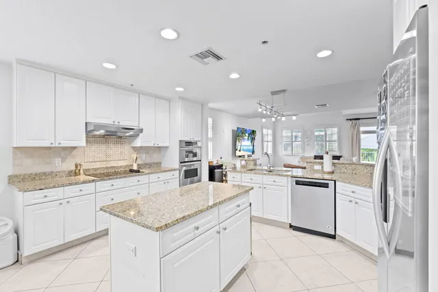 a kitchen with a sink stove cabinets and refrigerator