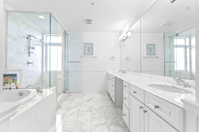a spacious bathroom with a tub sink double and mirror