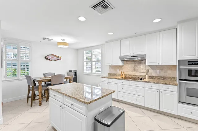 a kitchen with a sink white cabinets and appliances
