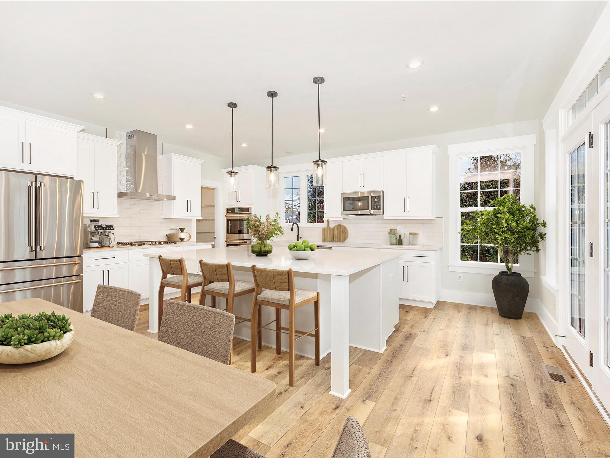 7022 Ridge Road Frederick, MD 21702 - Photo 16 of 63 a kitchen with stainless steel appliances a dining table chairs and a white refrigerator