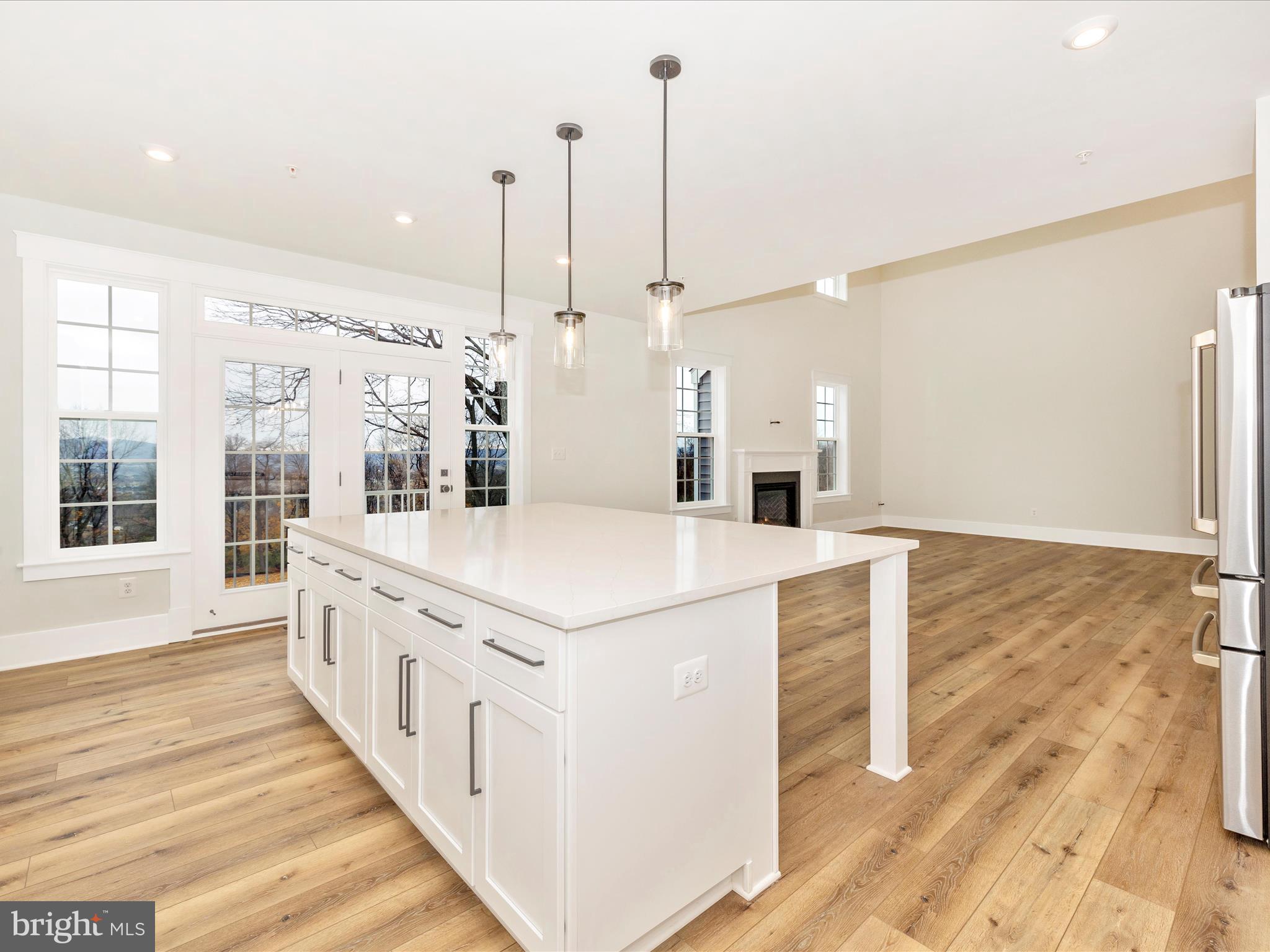 7022 Ridge Road Frederick, MD 21702 - Photo 21 of 63 a large white kitchen with wooden floor and a view of living room