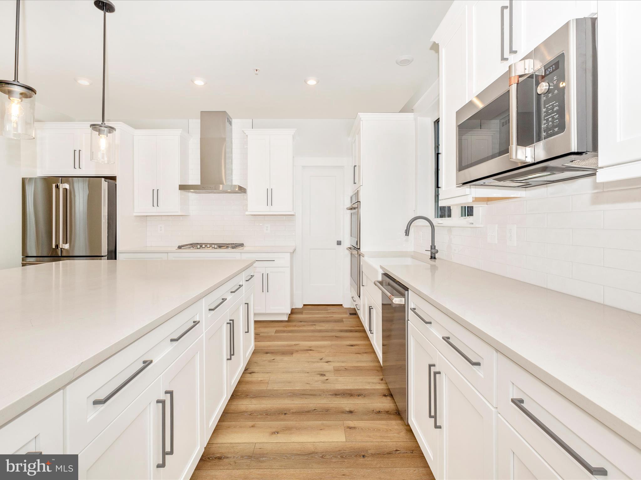 7022 Ridge Road Frederick, MD 21702 - Photo 23 of 63 a large kitchen with stainless steel appliances kitchen island granite countertop a sink and dishwasher a stove with wooden floor