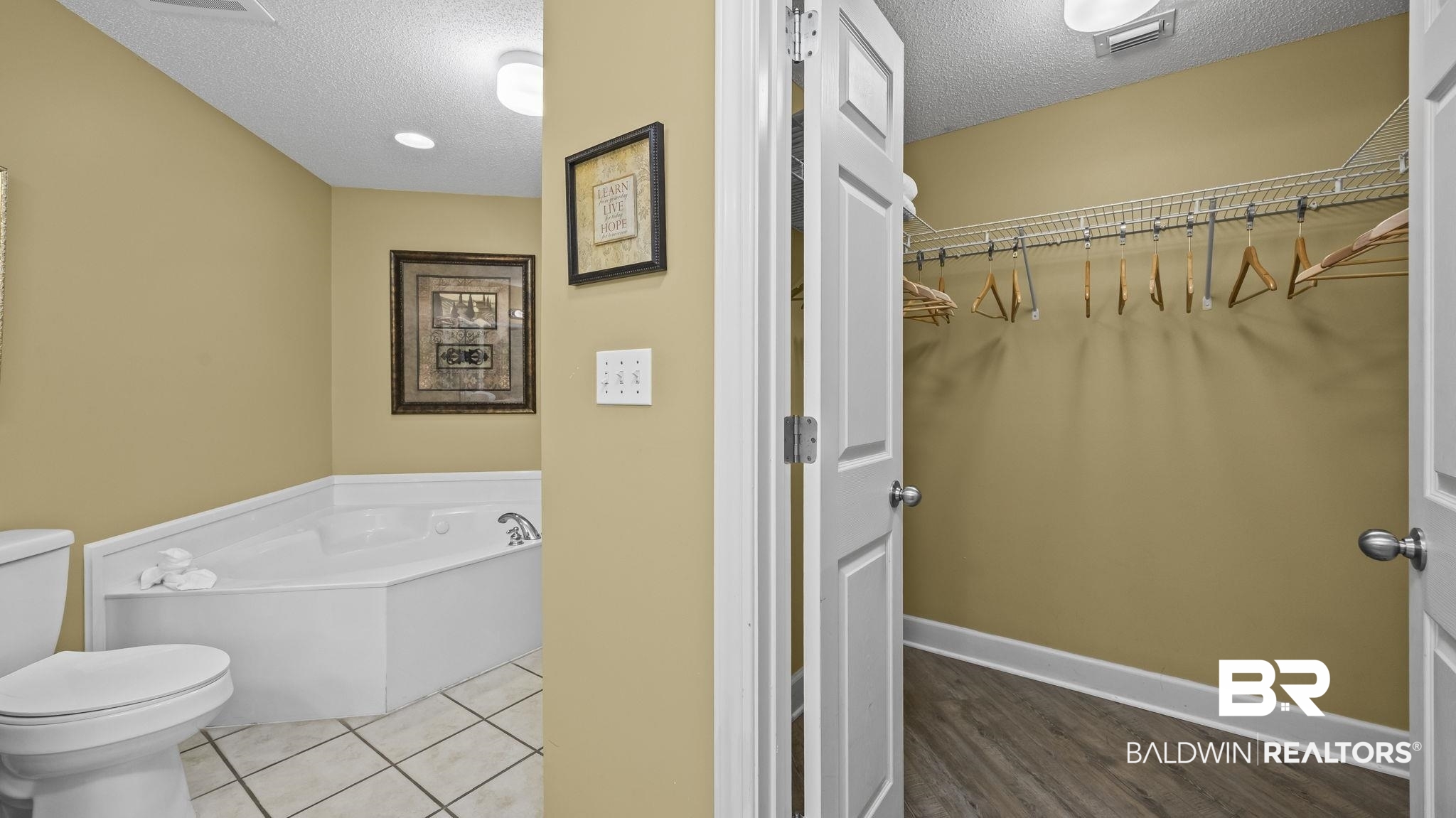 27580 Canal Road, Unit 214 BS 62 Orange Beach, AL 36561 - Photo 11 of 23 Bathroom featuring a garden tub, a textured ceiling, and a walk in closet