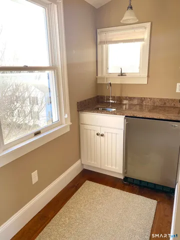 a view of a kitchen with wooden floor and a window