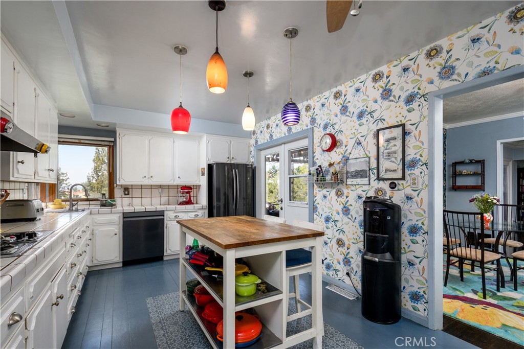13739 Ridge Road Whittier, CA 90601 - Photo 11 of 42 a kitchen with stainless steel appliances kitchen island granite countertop a table and chairs in it