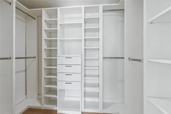 a view of walk in closet with empty racks