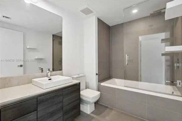 a bathroom with a sink toilet and mirror