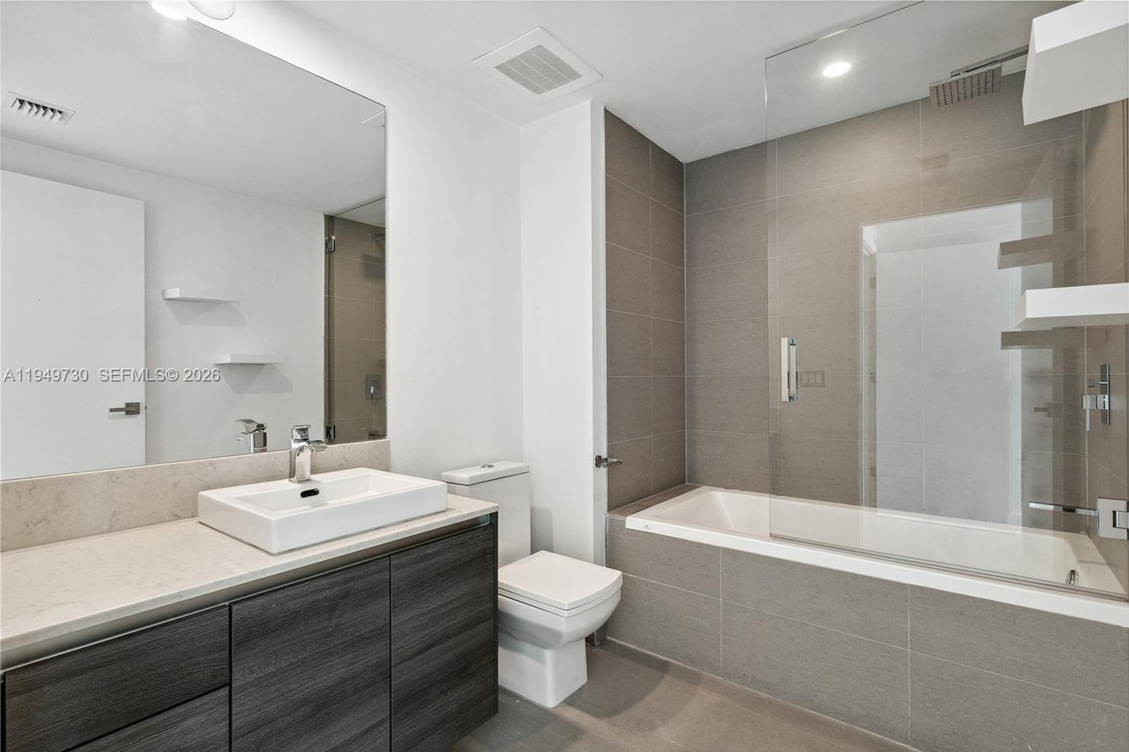 1080 Brickell Avenue, Unit 1401 Miami, FL 33131 - Photo 21 of 27 a bathroom with a double vanity sink toilet and shower