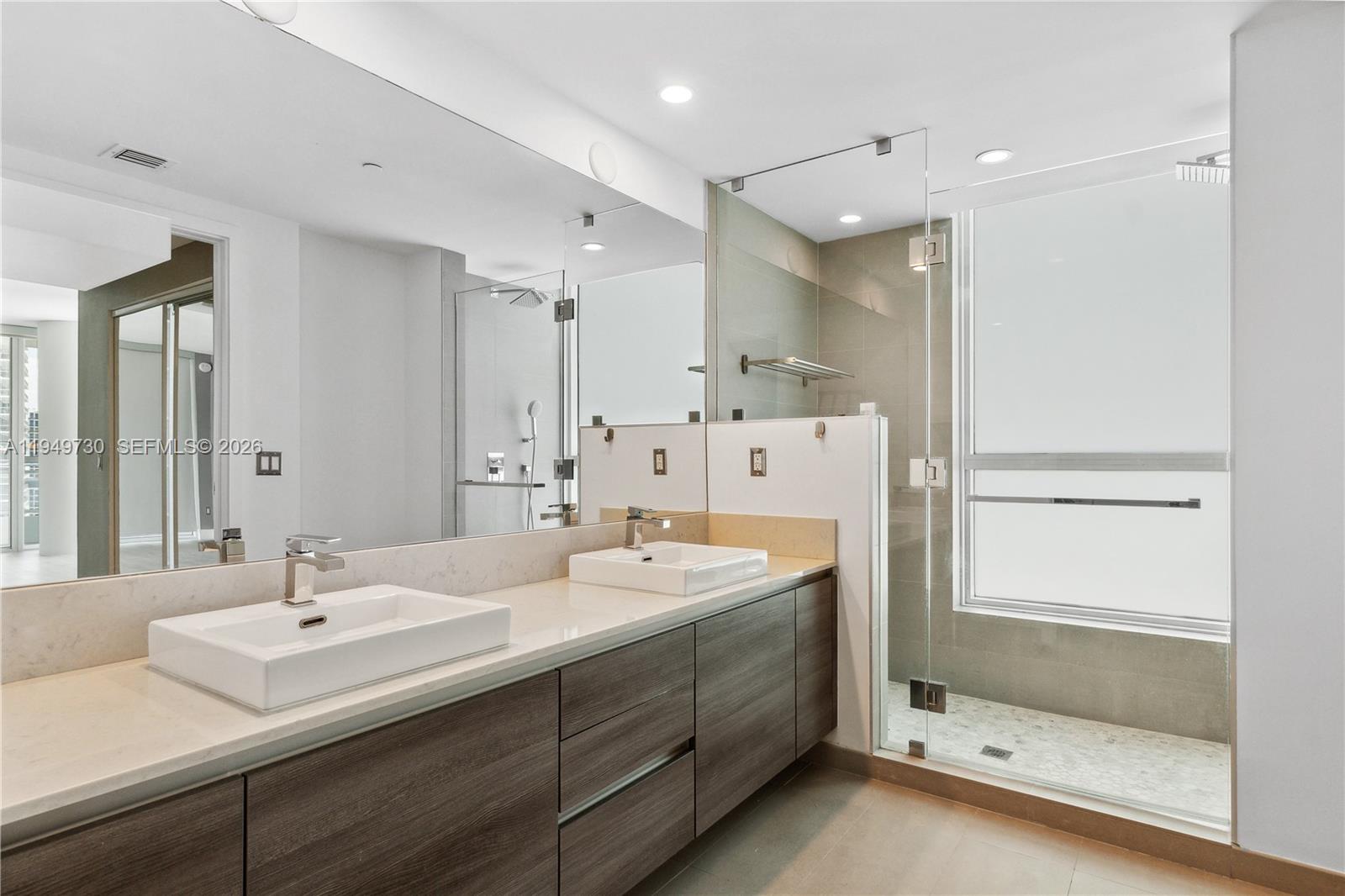 1080 Brickell Avenue, Unit 1401 Miami, FL 33131 - Photo 24 of 27 a bathroom with a shower sink and mirror