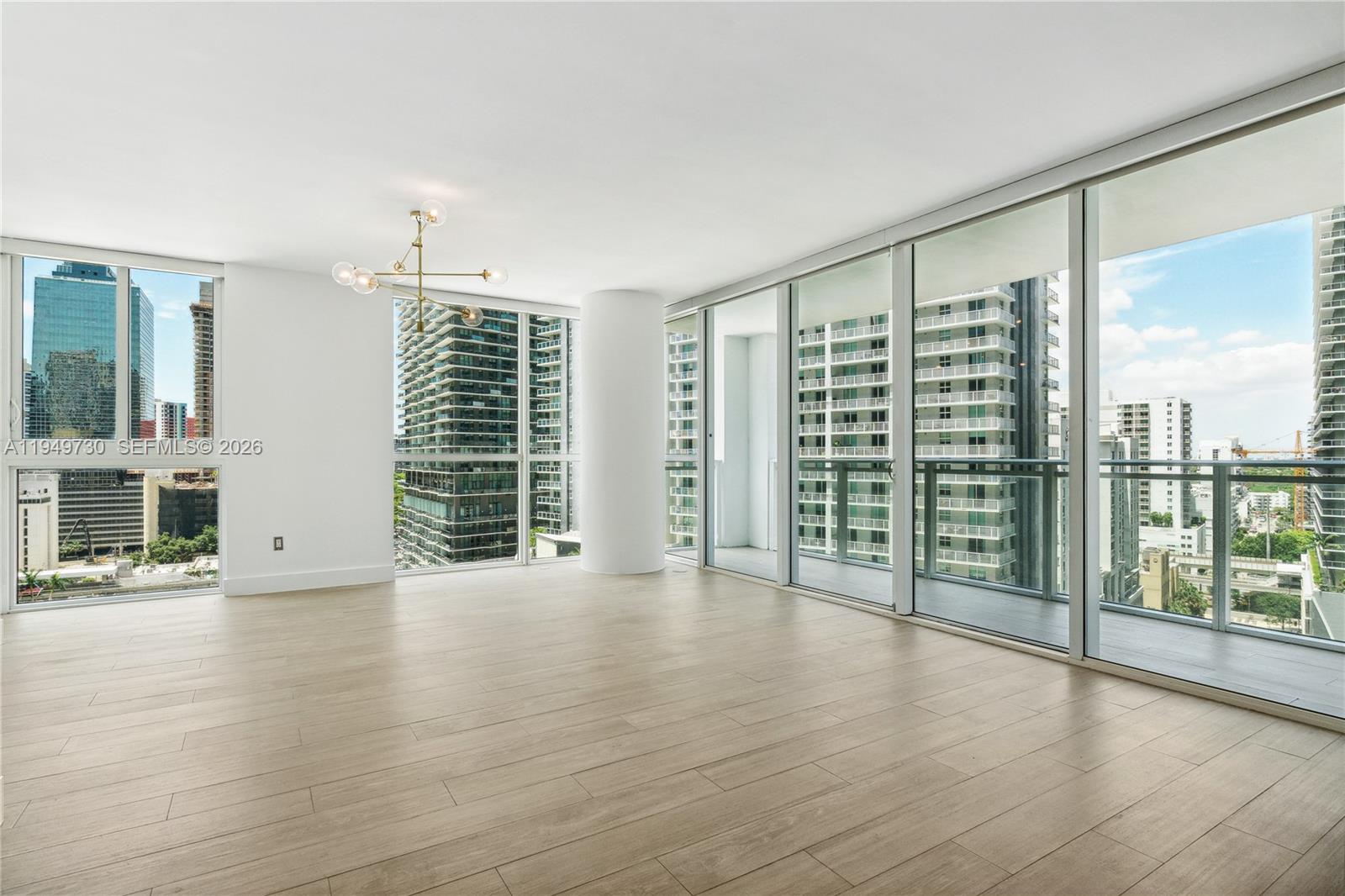 1080 Brickell Avenue, Unit 1401 Miami, FL 33131 - Photo 4 of 27 an empty room with wooden floor and windows