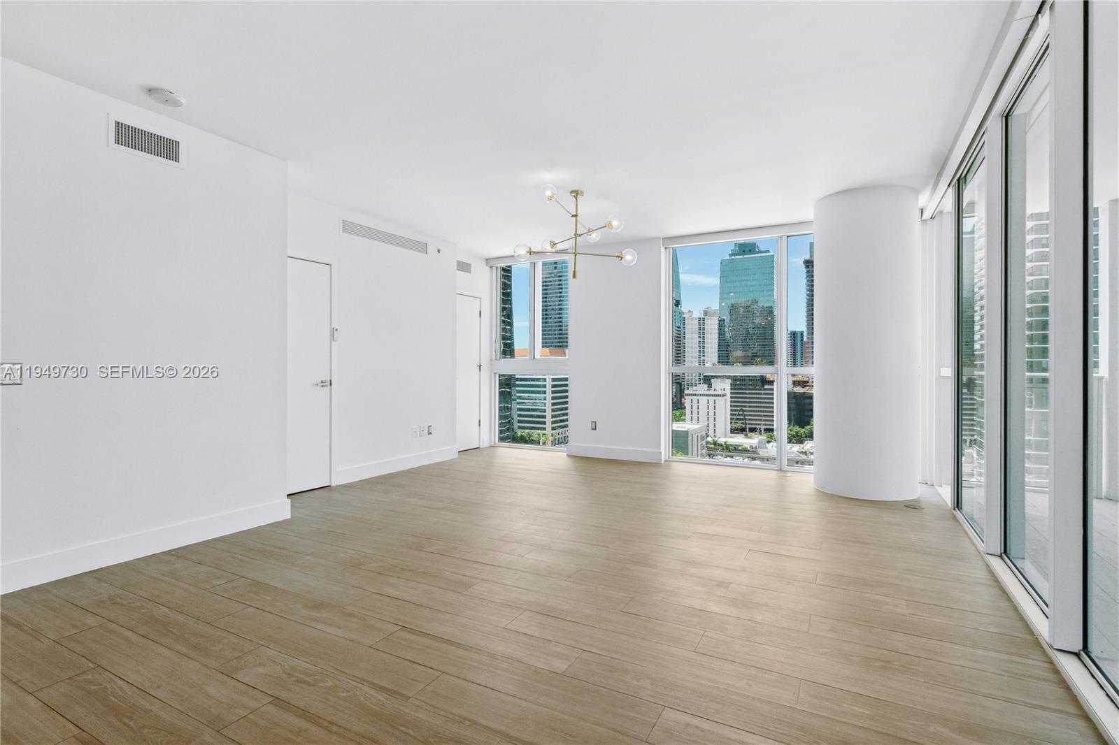 1080 Brickell Avenue, Unit 1401 Miami, FL 33131 - Photo 6 of 27 a view of an empty room with wooden floor and a window