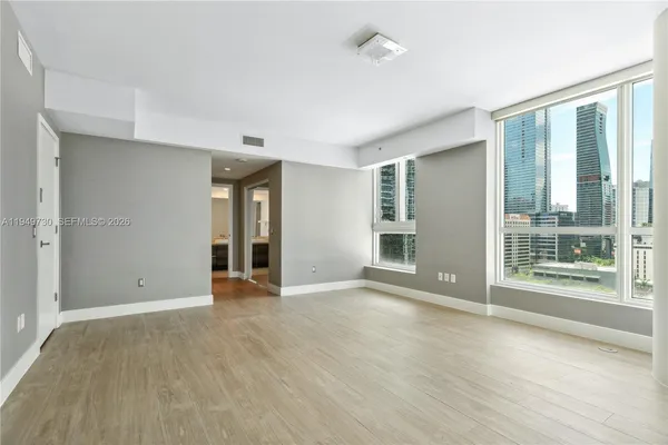 a view of an empty room with glass door and a window