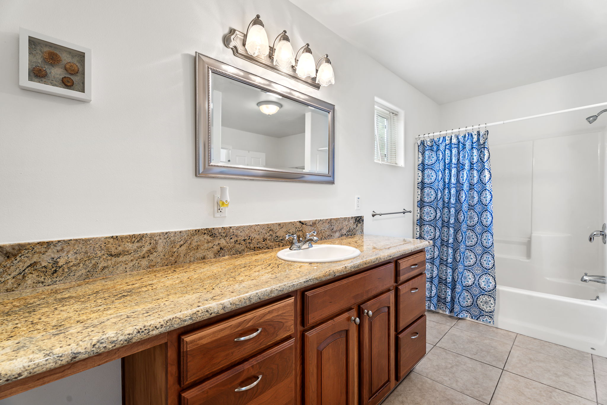 94-6494 Keoki Road Naalehu, HI 96772 - Photo 16 of 30 a bathroom with a granite countertop sink and a mirror