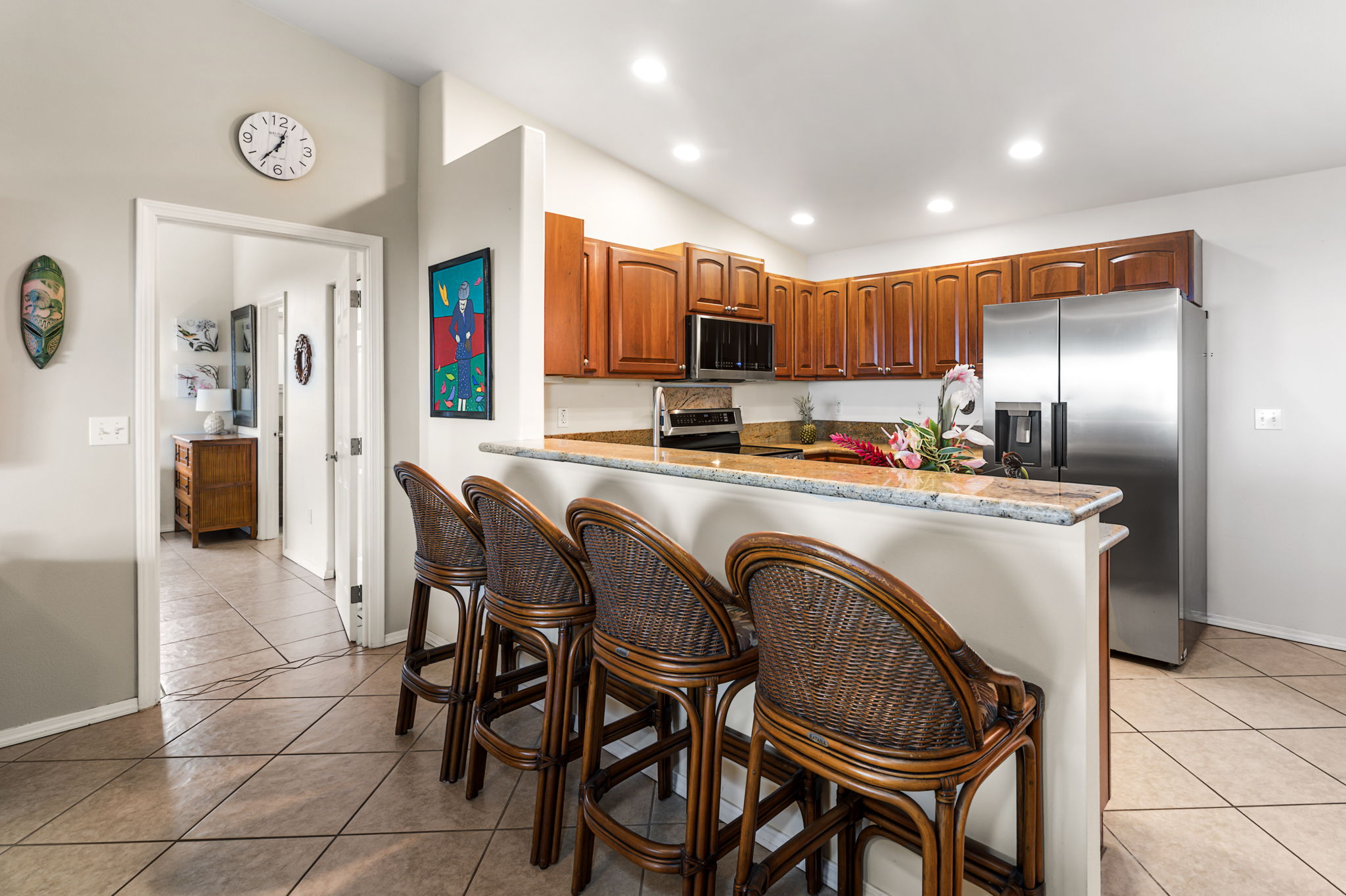 94-6494 Keoki Road Naalehu, HI 96772 - Photo 7 of 30 a kitchen with stainless steel appliances granite countertop a table chairs and a refrigerator