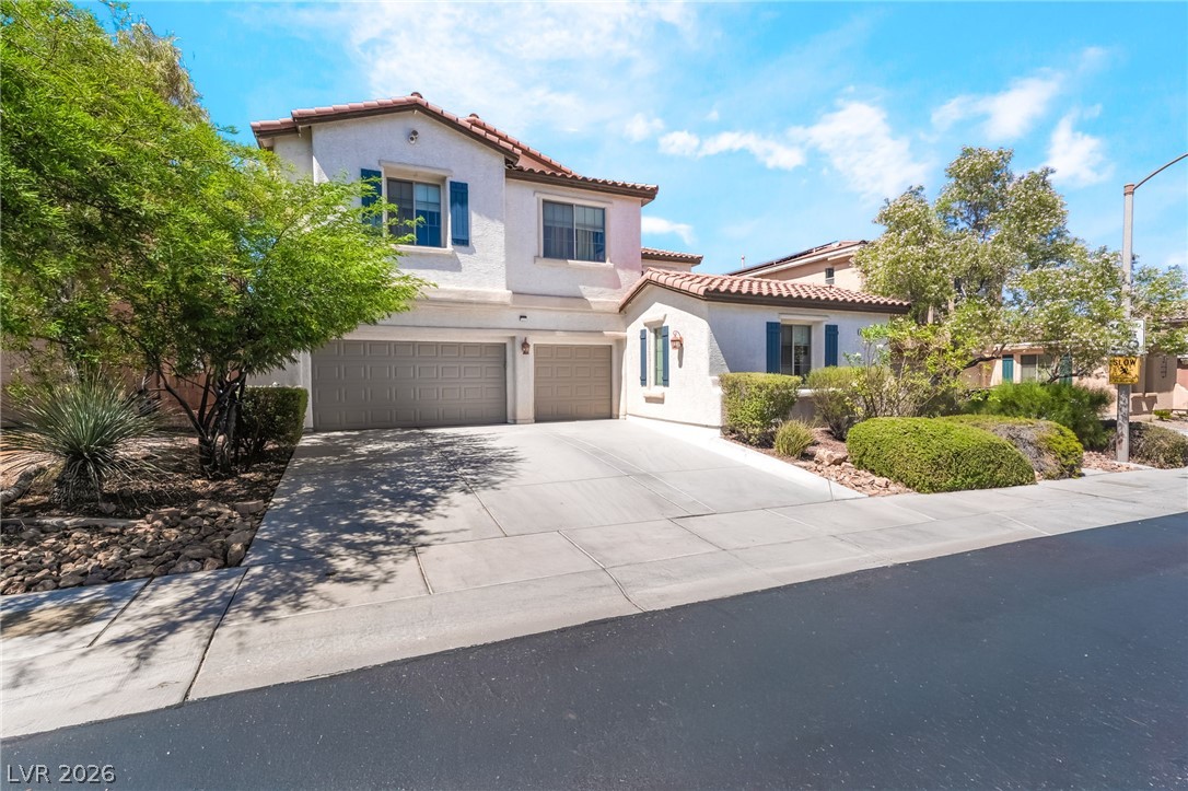 8358 Nelson Ridge Lane Las Vegas, NV 89178 - Photo 2 of 43 Two-story home with terracotta roof tiles and a spacious double garage offers charming curb appeal.
