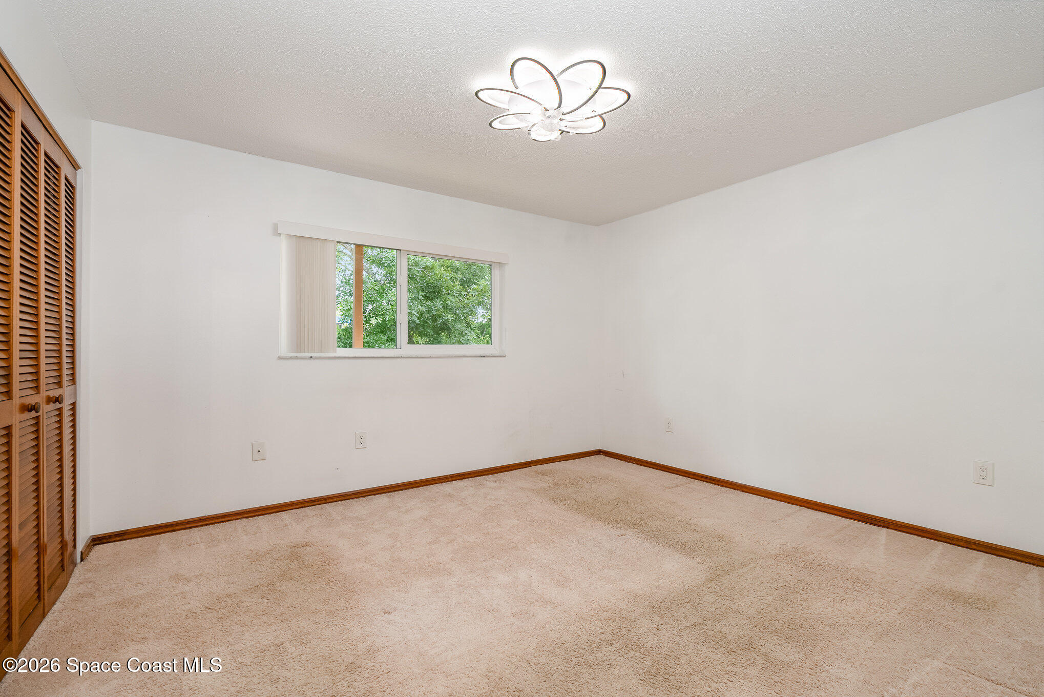 3021 Kirkland Road Northeast Palm Bay, FL 32905 - Photo 13 of 16 an empty room with a chandelier fan and window