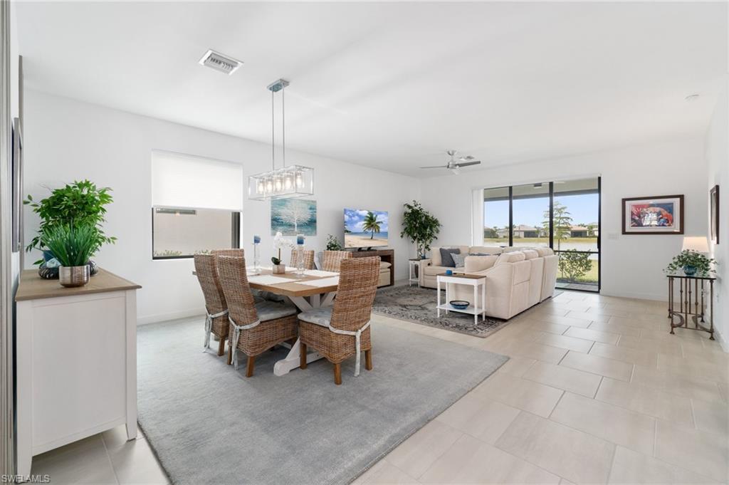 20238 Millrun Drive Estero, FL 33928 - Photo 9 of 41 a living room with furniture a chandelier and a dining table