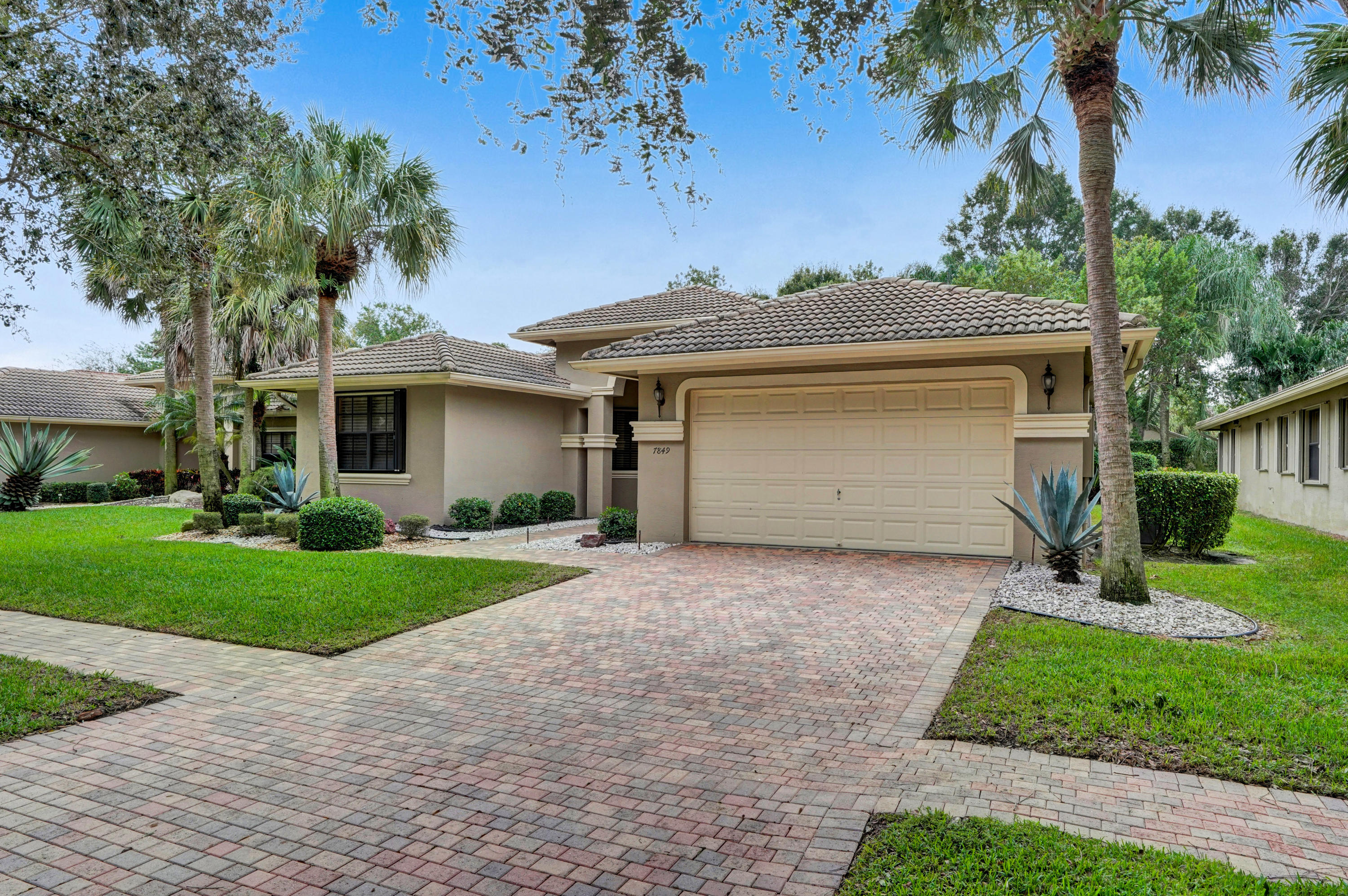 7849 Via Grande Boynton Beach, FL 33437 - Photo 2 of 59 a front view of a house with a yard and garage