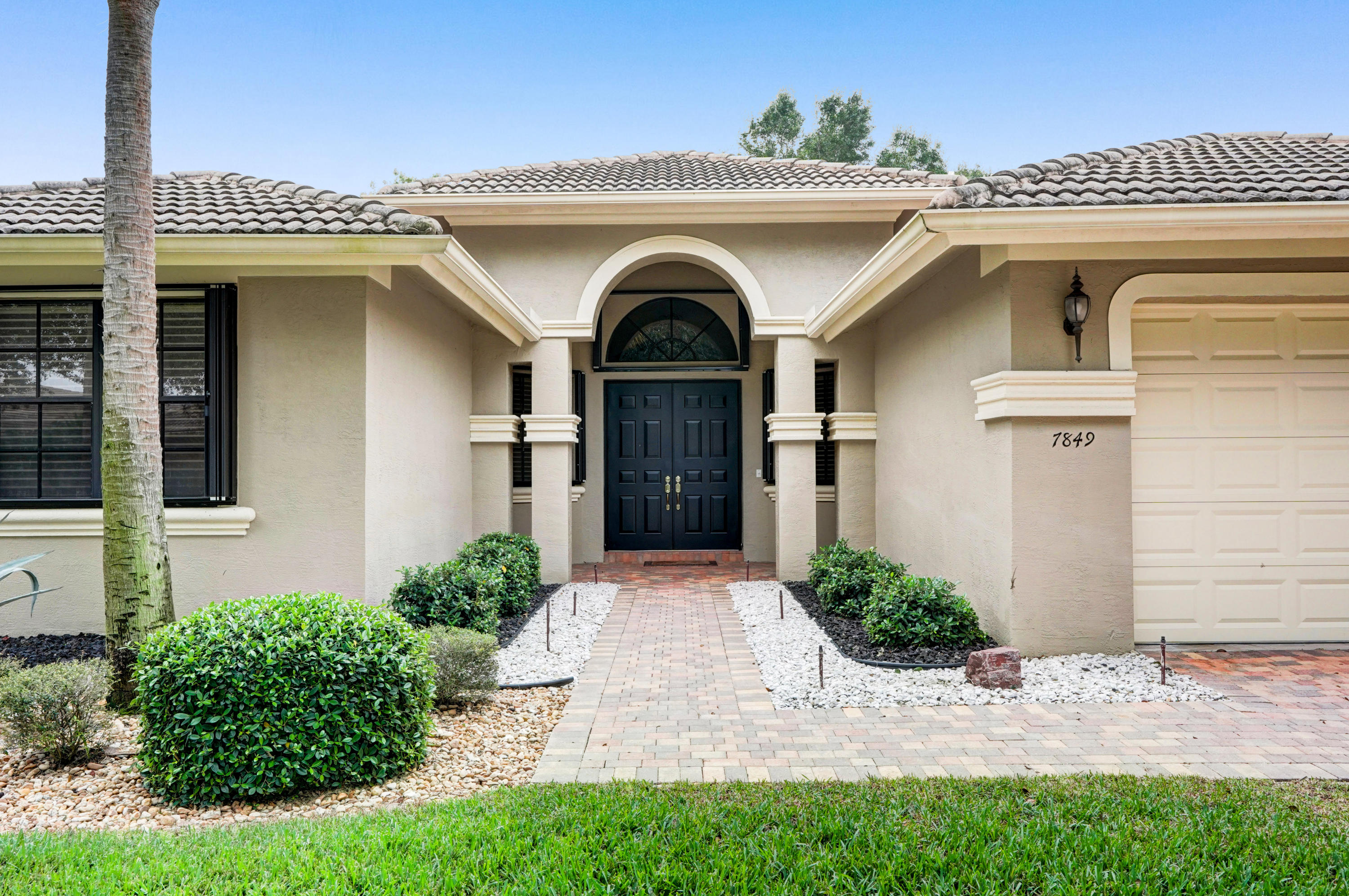 7849 Via Grande Boynton Beach, FL 33437 - Photo 4 of 59 a front view of a house with a garden
