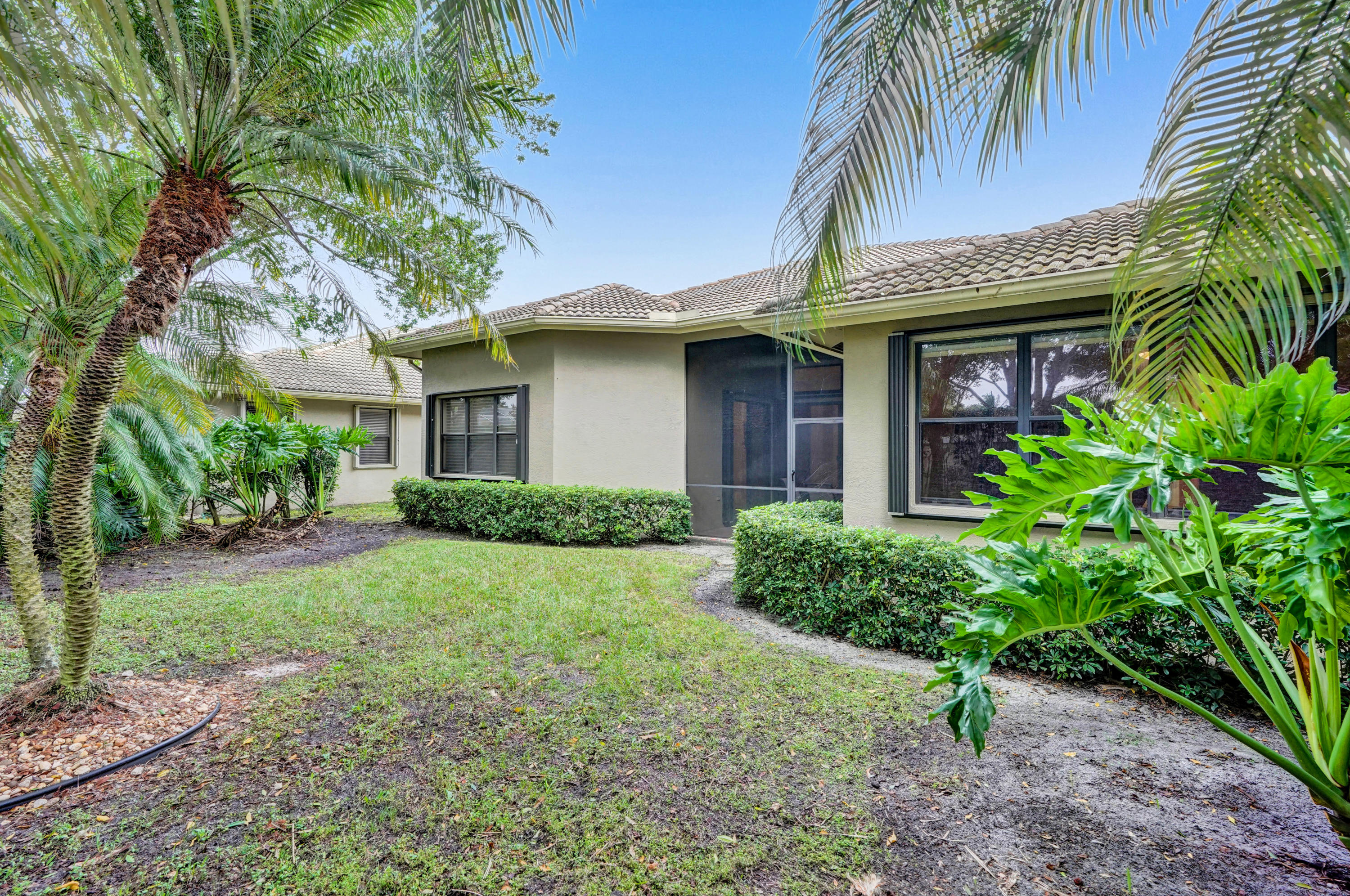 7849 Via Grande Boynton Beach, FL 33437 - Photo 8 of 59 a view of a white house with a large window and potted plants