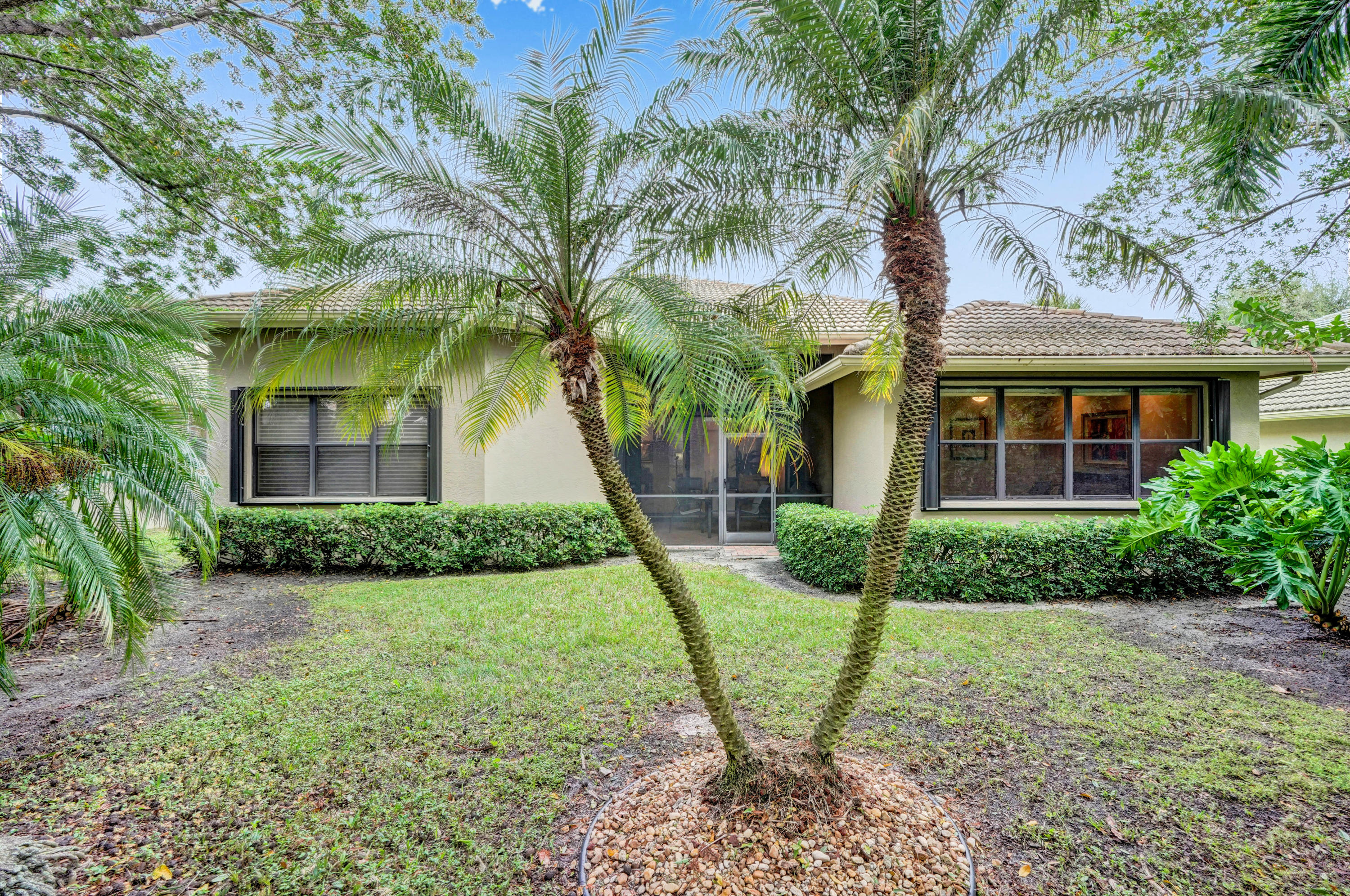 7849 Via Grande Boynton Beach, FL 33437 - Photo 9 of 59 a view of a brick house with a yard and large tree