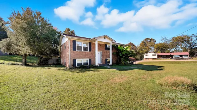a view of a house with swimming pool and a yard