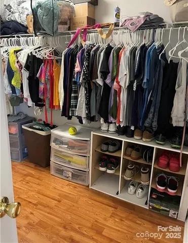 a view of walk in closet with clothes and shoes