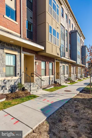 a kitchen with stainless steel appliances kitchen island granite countertop a stove top oven a sink dishwasher and a refrigerator with wooden floor