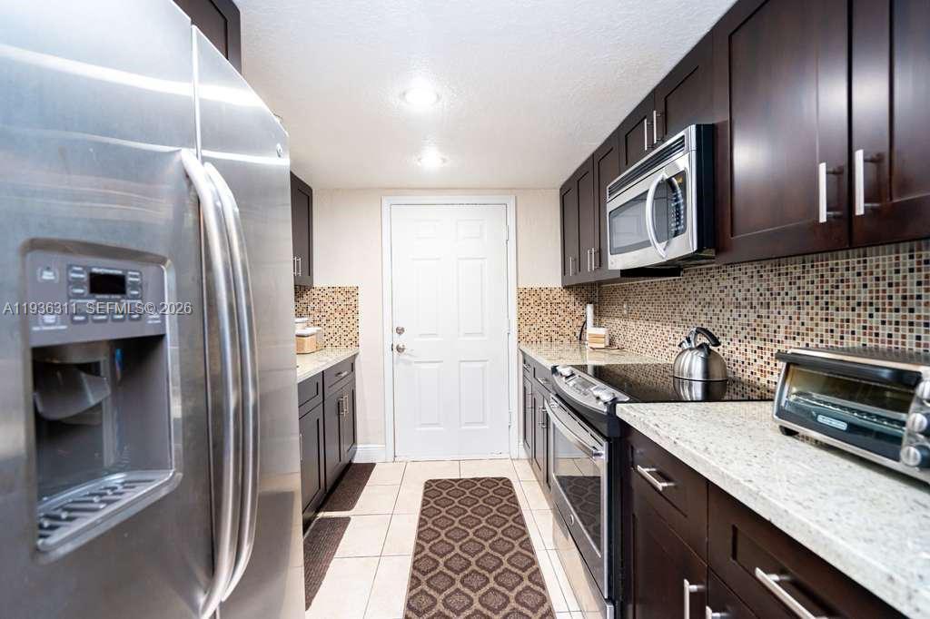 a kitchen with stainless steel appliances granite countertop a refrigerator and a sink